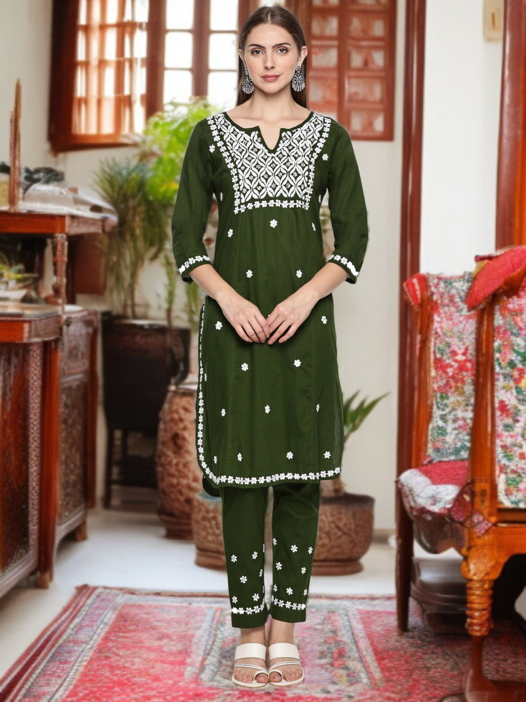 A woman wearing a traditional outfit with patterns in a decorated room. Mehndi