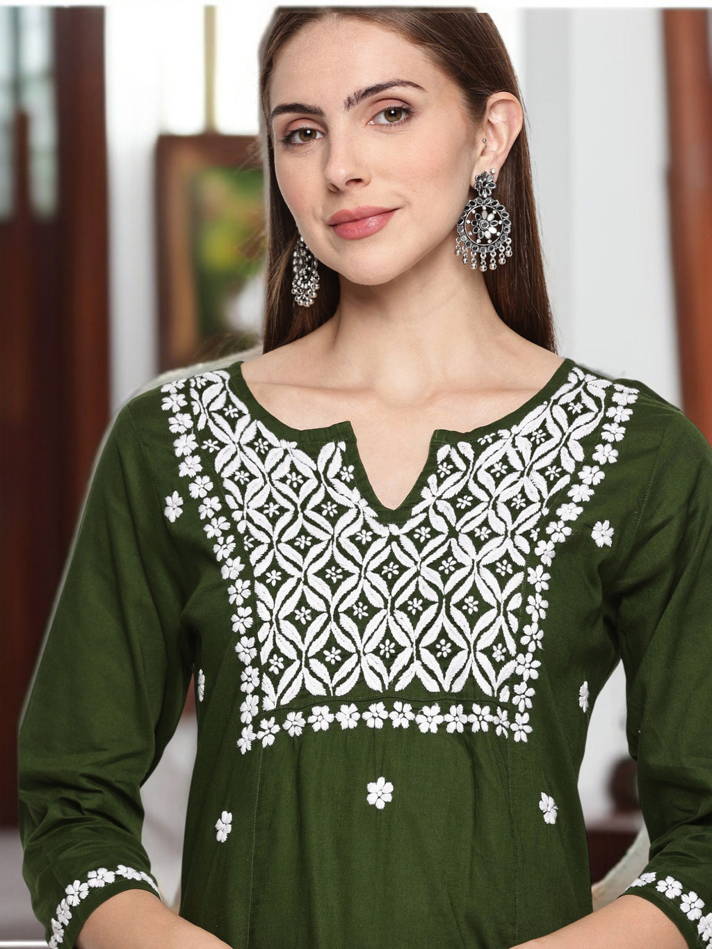 Woman wearing a  dress with embroidery in an indoor setting, mehndi