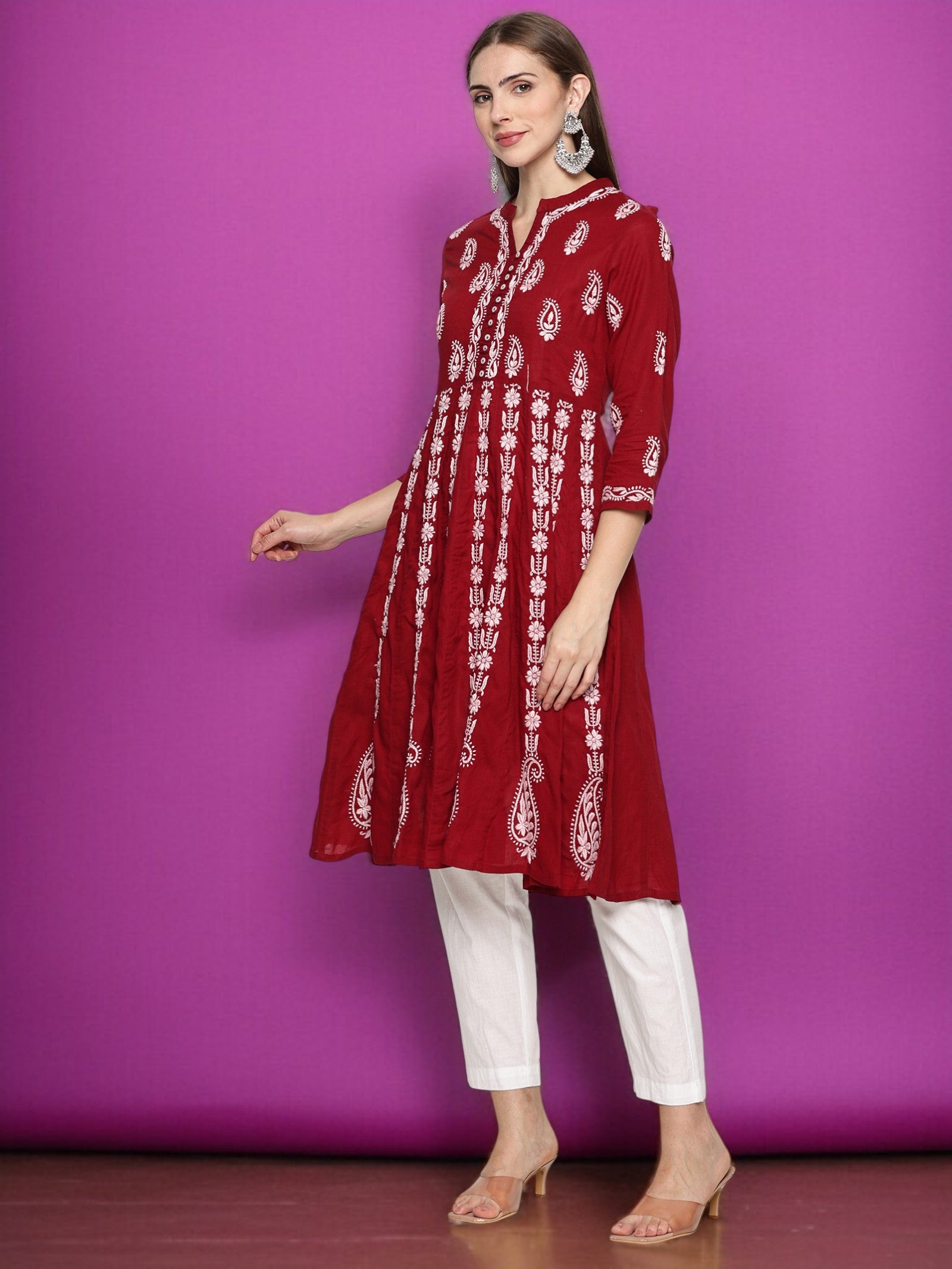Woman wearing a maroon and patterned kurta with pants against a purple background