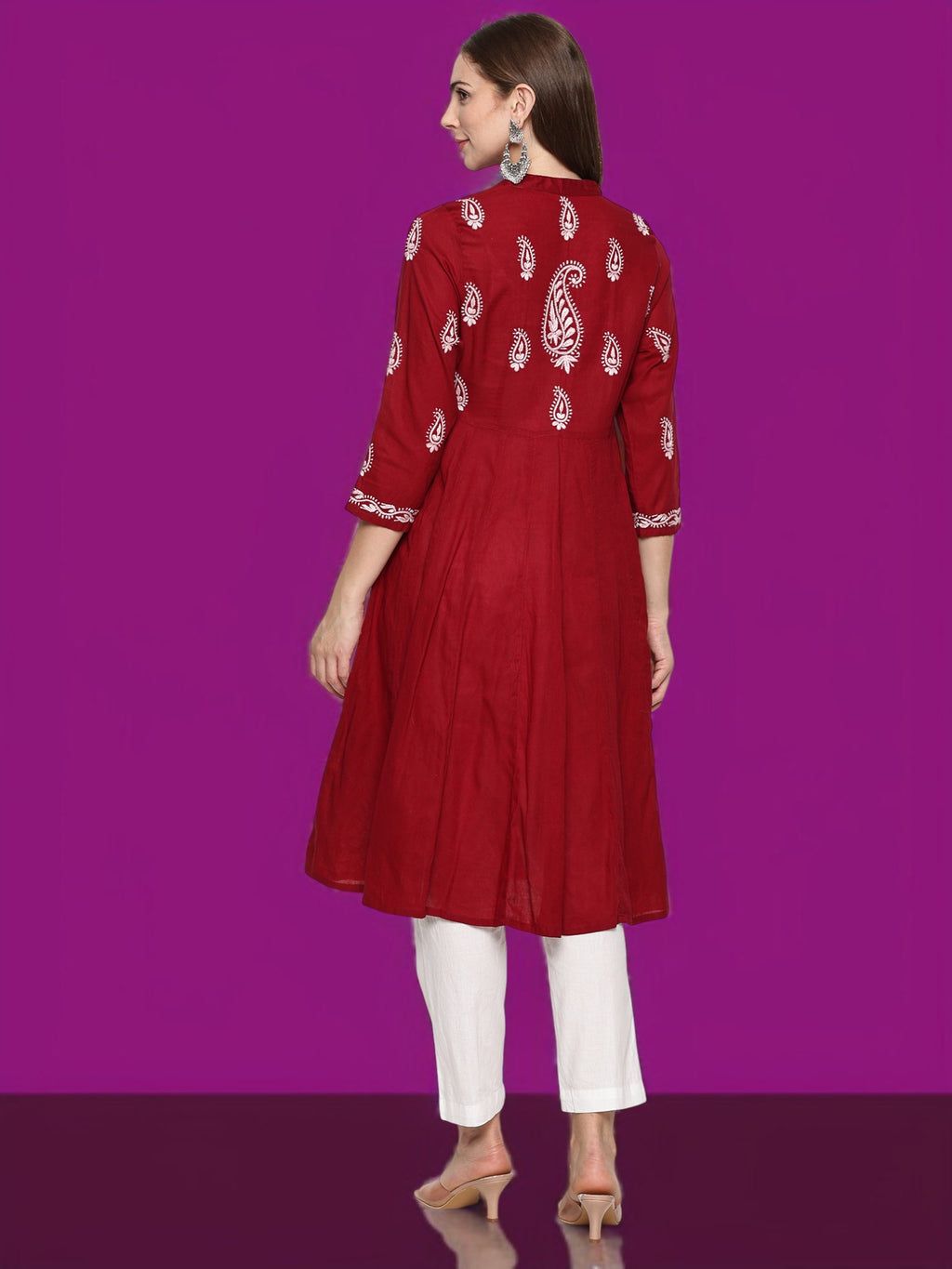 Woman wearing a maroon kurta with  patterns on a purple background