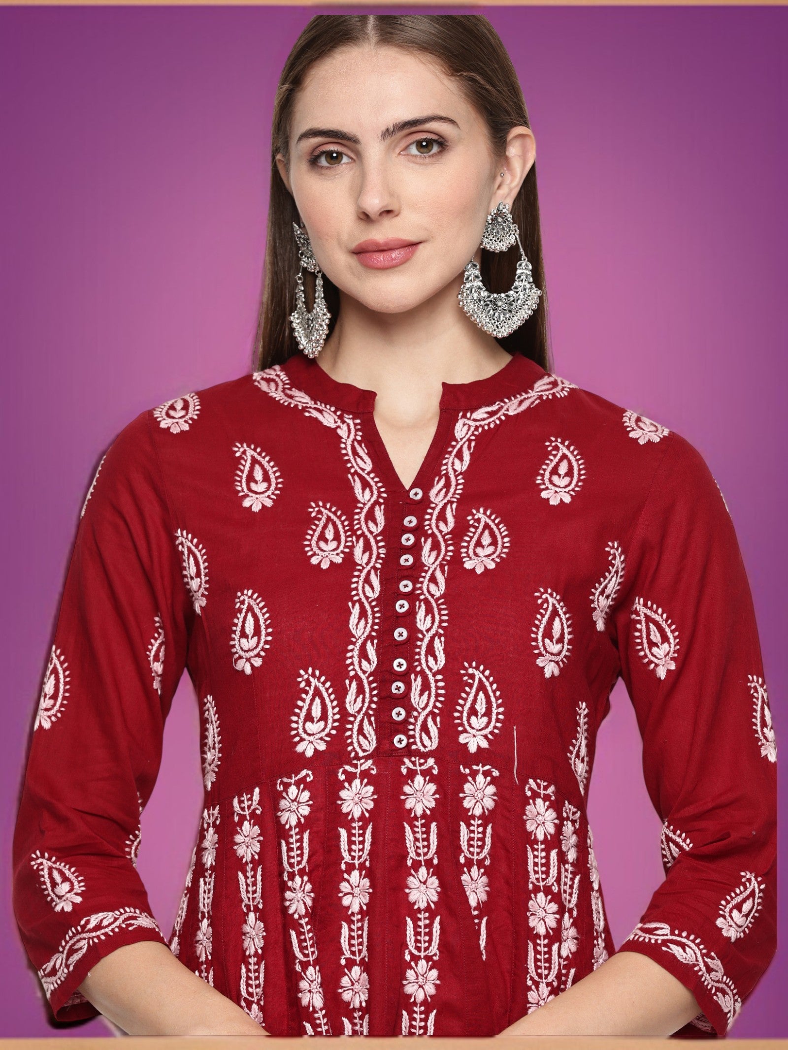 Woman wearing a Maroon  traditional outfit with  patterns on a purple background
