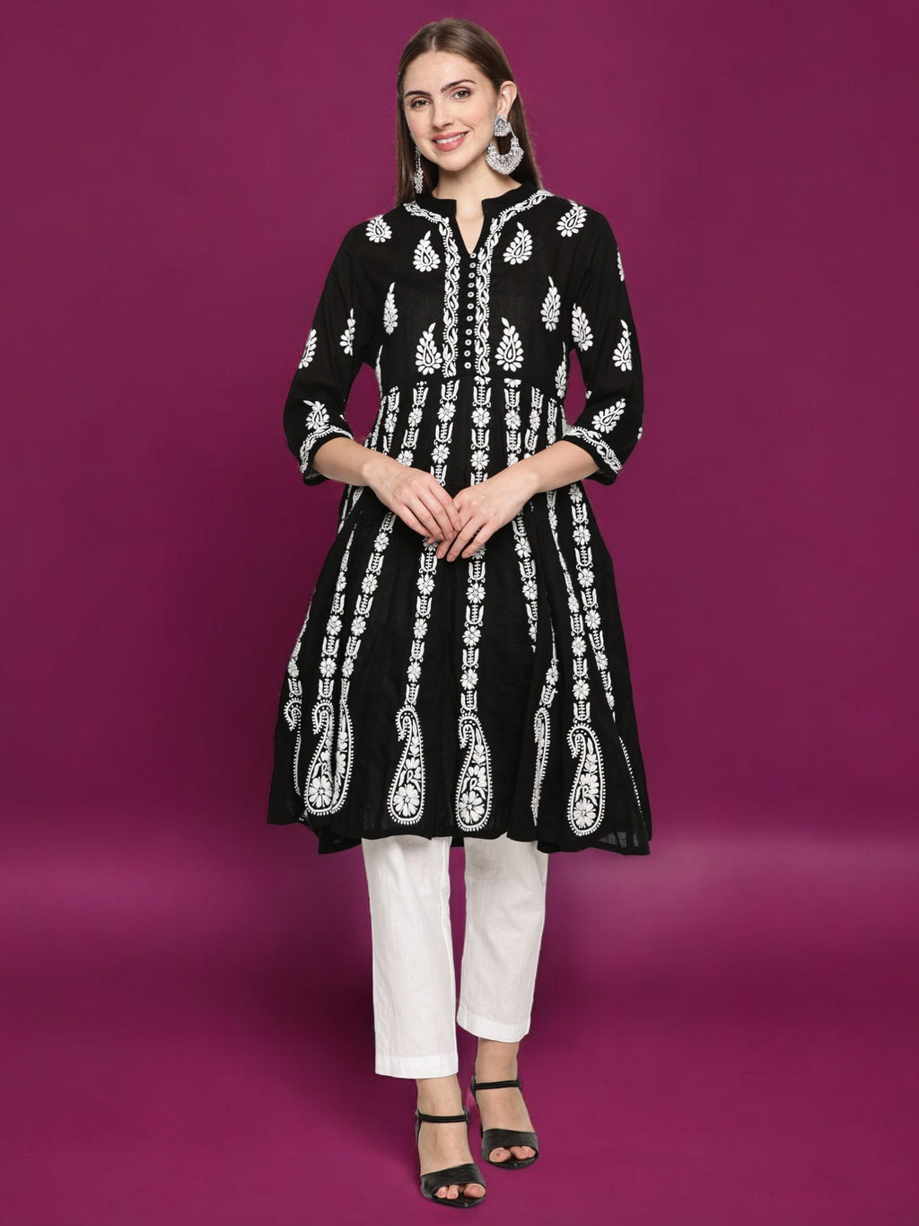 Woman wearing a black embroidered kurta with  pants on a purple background