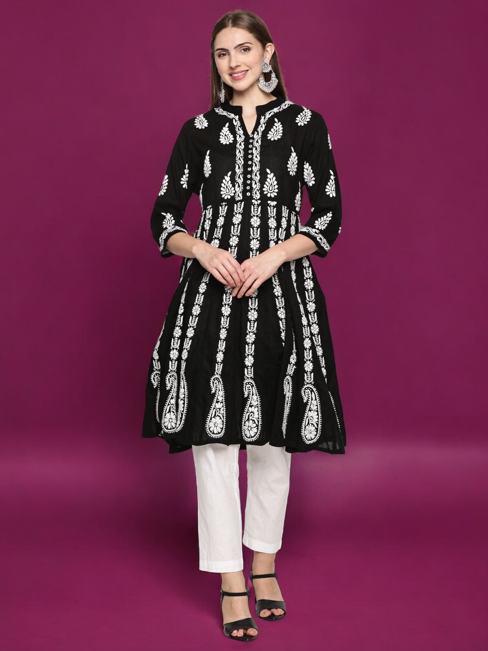 Woman wearing a black embroidered kurta with  pants on a purple background
