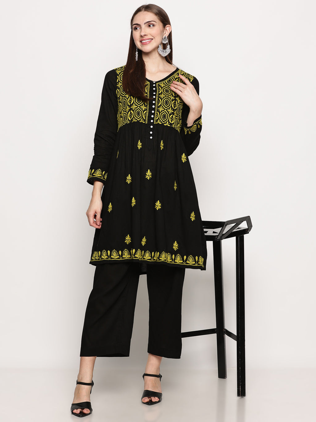Model wearing a black pure cotton chikankari co-ord set featuring lime green hand embroidery with chana pattai, ulti bakhiya, phanda, keel, and pechni stitches, V-neck, and full sleeves.