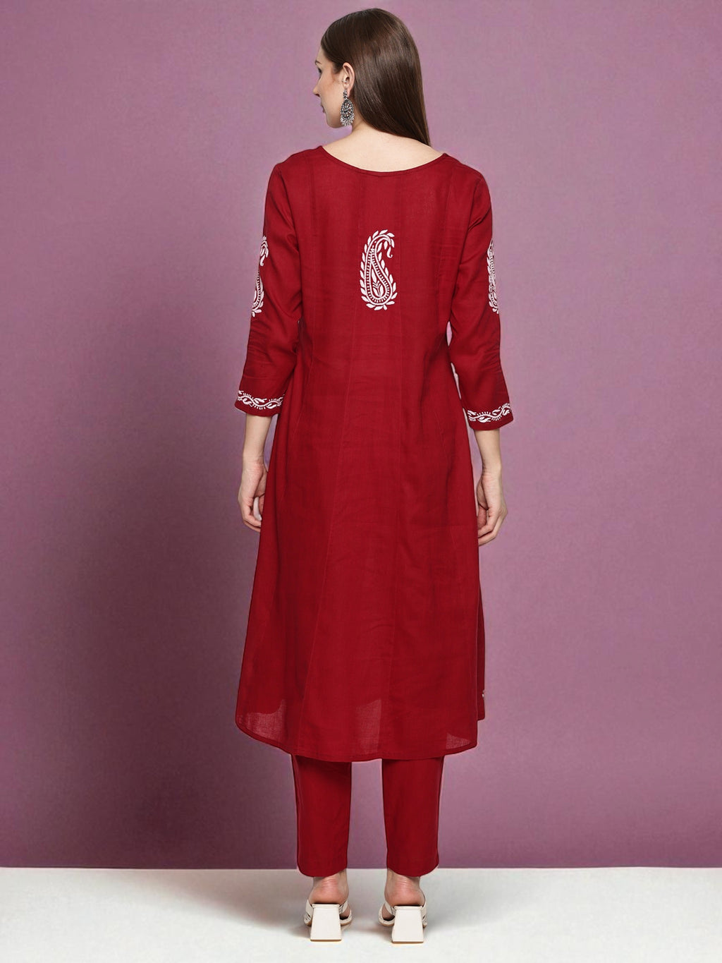 Red traditional outfit with white embroidery on a purple background